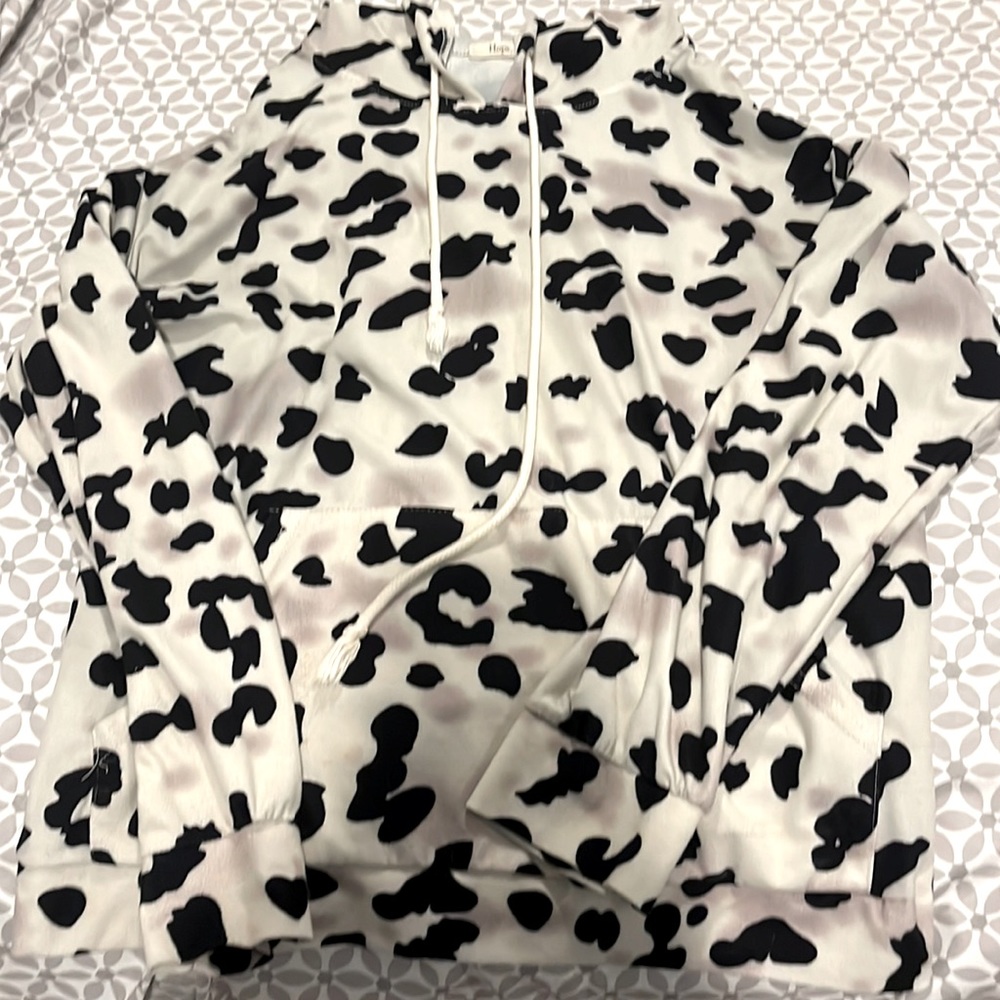 This is a cowprint hoodie in the size medium.